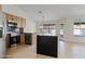 Open kitchen area with stainless steel appliances, wooden cabinetry, black countertops, and a large kitchen island at 438 E Hackamore St, Mesa, AZ 85203
