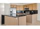 Stylish kitchen featuring wooden cabinets, a black countertop island, and modern stainless steel appliances at 438 E Hackamore St, Mesa, AZ 85203