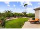 Picturesque backyard features manicured lawn, mature trees, landscaping, and lounge chair at 4517 E Sourwood Dr, Gilbert, AZ 85298