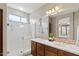 This bathroom features double sinks, a glass enclosed shower, and a large mirror with great lighting at 4517 E Sourwood Dr, Gilbert, AZ 85298