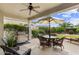 Relaxing covered patio featuring comfortable seating, ceiling fan, grill, and lush landscaping at 4517 E Sourwood Dr, Gilbert, AZ 85298