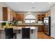 Well-lit kitchen with wood cabinets, granite countertops, stainless steel appliances, and breakfast bar at 4517 E Sourwood Dr, Gilbert, AZ 85298
