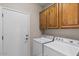 Convenient laundry room with washer, dryer, and wooden cabinets at 4517 E Sourwood Dr, Gilbert, AZ 85298