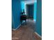 Hallway with a dark wood accent table featuring blue walls and tile floors at 4549 W Seldon Ln, Glendale, AZ 85302