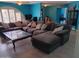 Spacious living room with a cozy sectional sofa, accent pillows and a distinctive glass-top coffee table at 4549 W Seldon Ln, Glendale, AZ 85302