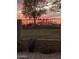 Beautiful backyard view with an iron fence overlooking a green landscape and Arizona sunset at 5450 E Mclellan Rd # 150, Mesa, AZ 85205