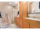Bathroom featuring a tile shower, vanity, and wood cabinets at 5450 E Mclellan Rd # 150, Mesa, AZ 85205