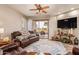 Comfortable living room featuring a leather sofa, ceiling fan and glass doors to the backyard at 5450 E Mclellan Rd # 150, Mesa, AZ 85205