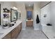 Modern bathroom featuring dual sinks, sleek cabinetry, and a glass-enclosed walk-in shower at 6094 N Sunrise Ln, Buckeye, AZ 85396