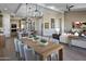 Open-concept dining area with wood floors, a stylish chandelier, and seamless connection to the living room and kitchen at 6094 N Sunrise Ln, Buckeye, AZ 85396