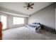 Minimalist bedroom with neutral carpet, a ceiling fan, a sliding glass door, and natural light at 656 W Johnson Dr, Gilbert, AZ 85233