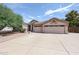 Front exterior view with desert landscaping, spacious driveway, and attached two-car garage with decorative details at 656 W Johnson Dr, Gilbert, AZ 85233