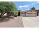 Single-story home showing the desert landscaping and spacious driveway leading to a two-car garage at 656 W Johnson Dr, Gilbert, AZ 85233
