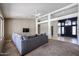 Open-concept living room with plush carpet, a gray sectional, and easy access to the entryway at 656 W Johnson Dr, Gilbert, AZ 85233