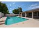 Beautiful backyard pool surrounded by lush landscaping and a covered patio at 656 W Johnson Dr, Gilbert, AZ 85233