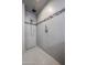 Walk-in shower featuring gray tile with decorative accent stripe, rainfall shower head, and handheld sprayer at 656 W Johnson Dr, Gilbert, AZ 85233