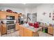 Functional kitchen with stainless steel appliances, tile floors, and oak cabinetry at 7215 N 76Th Ave, Glendale, AZ 85303