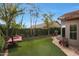 Relaxing backyard oasis with artificial turf, hammock, stone path, and lush landscaping at 7517 E Mariposa Grande Dr, Scottsdale, AZ 85255