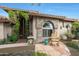 Charming home featuring a stone facade, arched window, and covered front porch with a cozy rocking chair at 7517 E Mariposa Grande Dr, Scottsdale, AZ 85255
