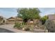 Charming single-story home featuring desert landscaping, barrel cactuses, and a cozy bench under a tree at 7517 E Mariposa Grande Dr, Scottsdale, AZ 85255