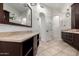 Bright bathroom featuring double vanities with stone countertops, tile flooring, and modern lighting at 823 W Palo Verde Dr, Phoenix, AZ 85013