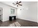 Bright bedroom features a ceiling fan, modern desk, wood floors, and a window with shutter-style blinds at 823 W Palo Verde Dr, Phoenix, AZ 85013