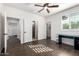 Bright bedroom with wood floors features a ceiling fan, a modern desk and a view to closet and ensuite at 823 W Palo Verde Dr, Phoenix, AZ 85013