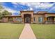 Stunning single-story home featuring a beautiful lawn, brick walkway, and an elegant covered entryway with wooden accents at 823 W Palo Verde Dr, Phoenix, AZ 85013