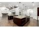 Open concept kitchen with a large island, hardwood floors, high ceilings, and modern light fixtures at 823 W Palo Verde Dr, Phoenix, AZ 85013