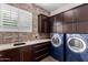 Well-equipped laundry room with brick accents, sink, counters, and washer/dryer at 823 W Palo Verde Dr, Phoenix, AZ 85013