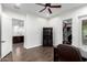 Bright office space features dark hardwood floors, ceiling fan and built-in shelving units and an open view into the kitchen at 823 W Palo Verde Dr, Phoenix, AZ 85013