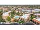 Aerial view featuring an apartment complex, manicured landscaping, pool, and surrounding parking, city buildings, and green spaces at 8256 E Arabian Trl # 239, Scottsdale, AZ 85258