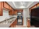 Cozy kitchen featuring wooden cabinets, tile floors, and updated appliances at 8256 E Arabian Trl # 239, Scottsdale, AZ 85258