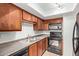 Compact kitchen features wooden cabinets, black appliances and a double basin sink at 8256 E Arabian Trl # 239, Scottsdale, AZ 85258