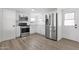 Bright kitchen featuring stainless steel appliances, white cabinets, and wood-look floors at 848 W Calle Del Norte --, Chandler, AZ 85225