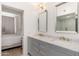 Bright bathroom featuring double sinks, a marble countertop, and a glimpse to the primary bedroom at 902 W Glendale Ave # 215, Phoenix, AZ 85021