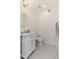 Charming powder room with decorative floor tiles, a white vanity with a marble countertop and gold fixtures at 902 W Glendale Ave # 215, Phoenix, AZ 85021