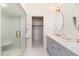 Beautiful bathroom with double sinks, elegant vanities, and a glass-enclosed shower next to a walk-in closet at 902 W Glendale Ave # 215, Phoenix, AZ 85021
