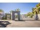 Gated community entrance with metal gates and desert landscaping under a bright blue sky at 902 W Glendale Ave # 215, Phoenix, AZ 85021