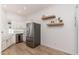Spacious kitchen featuring stainless steel refrigerator, farmhouse sink, and floating shelves at 902 W Glendale Ave # 215, Phoenix, AZ 85021