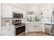 Bright kitchen featuring stainless steel appliances, white cabinetry, and a farmhouse sink at 902 W Glendale Ave # 215, Phoenix, AZ 85021