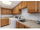 Functional laundry room equipped with a washer, a sink, and ample storage space with wooden cabinets at 902 W Glendale Ave # 215, Phoenix, AZ 85021