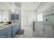 Modern bathroom features marble floors, double sink vanity, and a walk-in shower with glass block window at 9053 N 123Rd St, Scottsdale, AZ 85259
