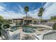 Resort-style backyard with pool, spa, outdoor kitchen, and mature palm trees for a tropical feel at 9053 N 123Rd St, Scottsdale, AZ 85259
