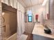 Well-maintained bathroom featuring a shower and tub combination, vanity, and floral wallpaper at 9333 E University Dr # 184, Mesa, AZ 85207