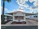 Charming manufactured home featuring covered parking and a well-maintained front yard with decorative landscaping at 9333 E University Dr # 184, Mesa, AZ 85207