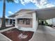 Inviting manufactured home boasts a covered carport and landscaped front yard, offering a cozy curb appeal at 9333 E University Dr # 184, Mesa, AZ 85207