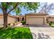 Charming single-story home boasts lush front lawn, mature tree, and a two-car garage at 9717 E Holiday Way, Sun Lakes, AZ 85248