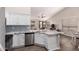 Stylish kitchen with white cabinets, stainless steel appliances, and an island overlooking the living area at 9717 E Holiday Way, Sun Lakes, AZ 85248