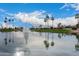 Scenic community pond with a beautiful water fountain, lush green landscape, and palm tree accents at 9717 E Holiday Way, Sun Lakes, AZ 85248